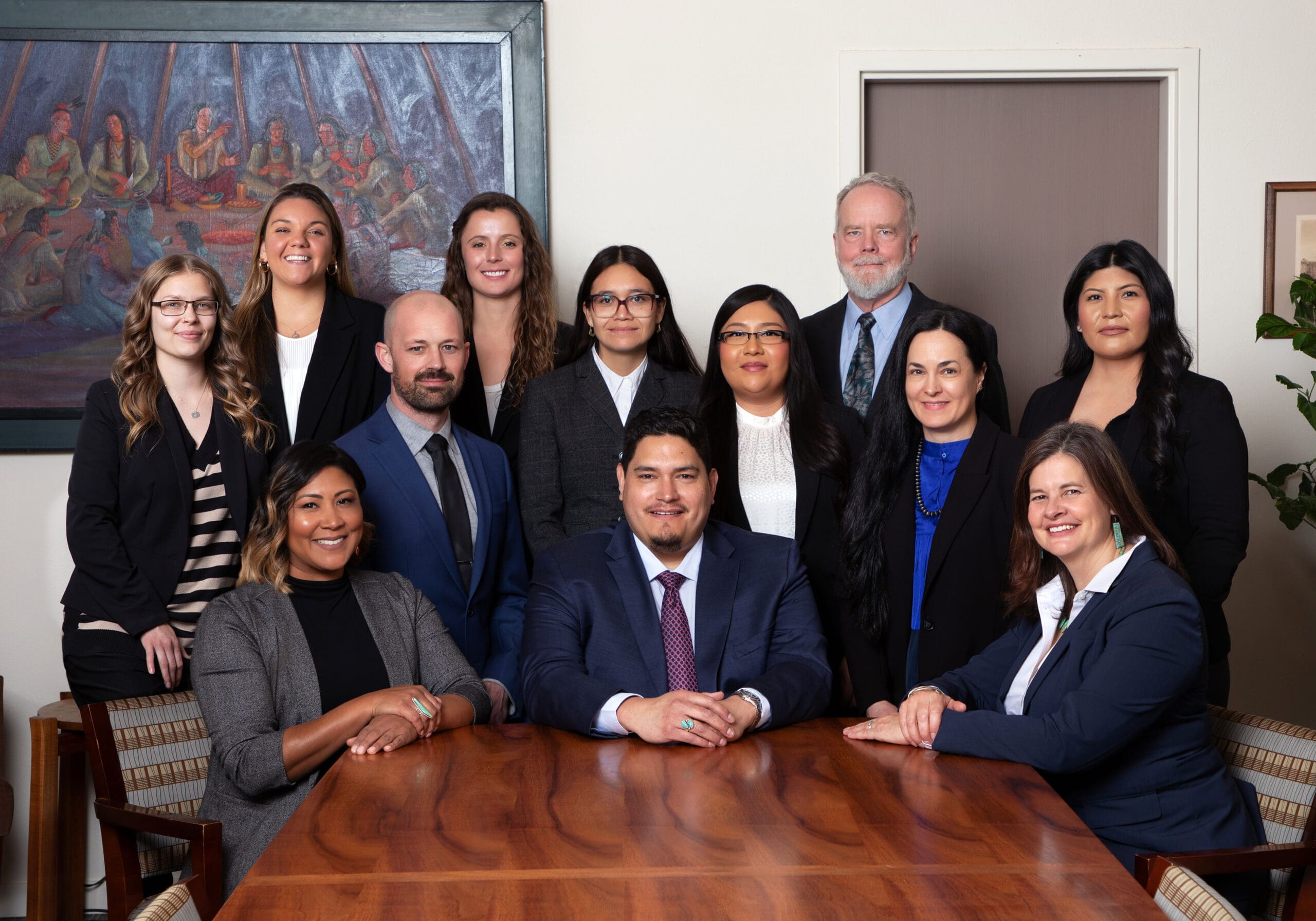 BKSW Employees and partners sitting around a meeting table, smiling for a picture.